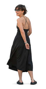 woman in a black dress standing and looking back
