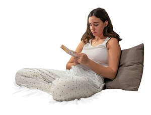 cut out woman in her pajamas sitting on the bed and reading