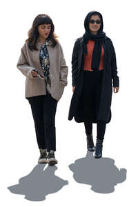 two backlit middle eastern women walking