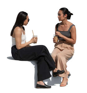 two asian women sitting and drinking coffee