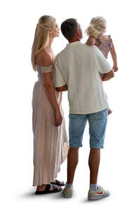 man and woman with a little child standing by the window and looking outside