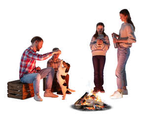 family with a dog sitting around the bonfire