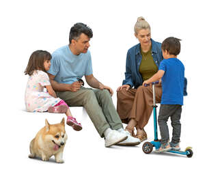 family with kids and a dog sitting and talking