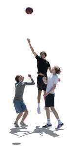 backlit group of teenage boys playing basketball