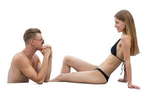 man in a pool talking to a woman sunbathing by the pool