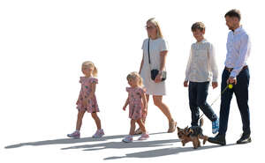 backlit family with kids and a dog walking