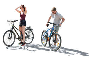 backlit man and woman on bikes stopping