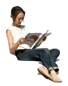 asian woman sitting on a sofa and reading a magazine
