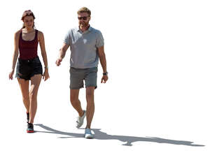 man and woman walking in the summer in backlight