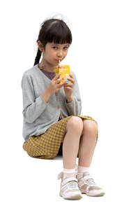 little japanese girl sitting and drinking juice