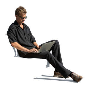man casually sitting and working with a laptop