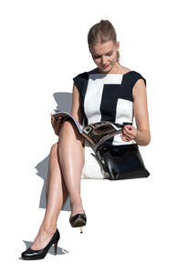 elegant woman in a dress and wearing high heels sitting and reading