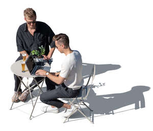 top view of two men sitting in a cafe and looking at a laptop