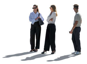 three backlit people standing and looking around