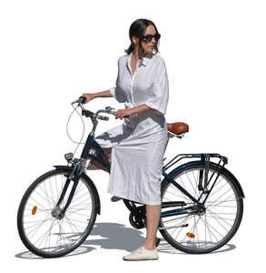 woman in a white summer dress standing with a bike