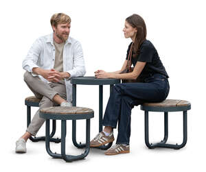 man and woman sitting at an outdoor area table and talking