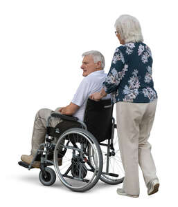 elderly woman walking with a man in a wheelchair