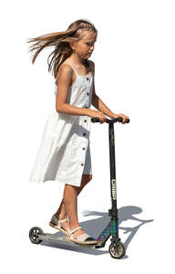 little girl in a summer dress riding a scooter