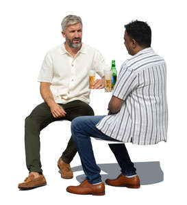 two men sitting outside and drinking beer