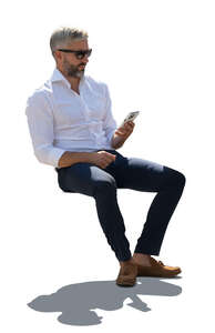 man in a suit sitting outside in backlight