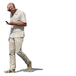 man in white walking with a phone in his hand