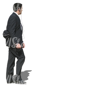 man in a black suit walking and taking pictures