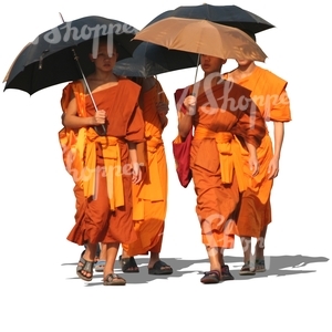 four buddhist monks walking with umbrellas