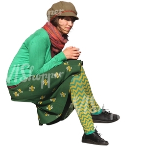 bohemian woman in a green outfit sitting