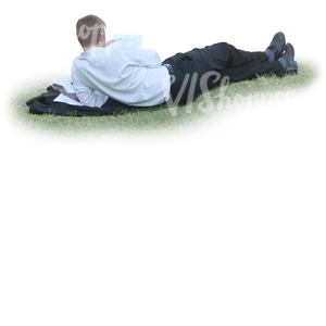 businessman lying on the grass and reading