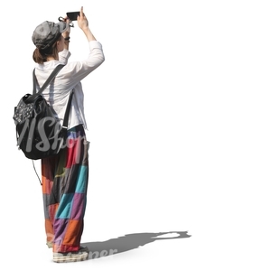 woman with a backpack standing and taking a picture