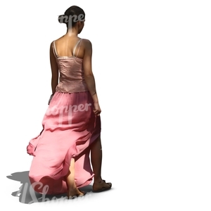 woman in a long pink skirt walking in tree shade