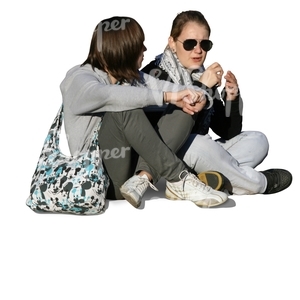 two girls sitting and talking on the sidewalk