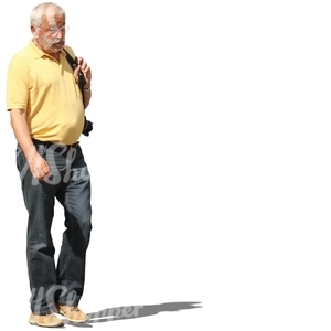 grey-haired man with a camera walking
