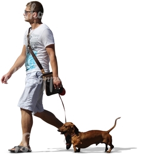 man in white shorts walking a dog