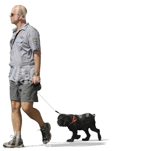 A man walking a black dog