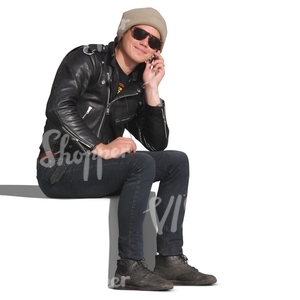 man in a leather jacket sitting and talking on the phone