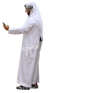 arab man in a white thobe looking at his phone