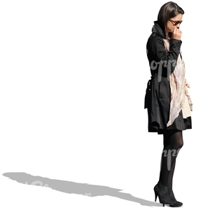 businesswoman in a black coat standing and thinking