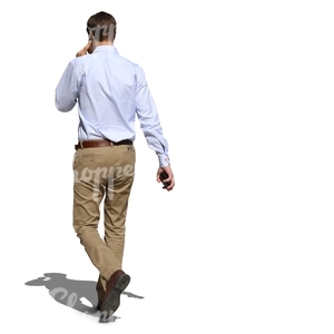 man in a white shirt walking and talking on the phone