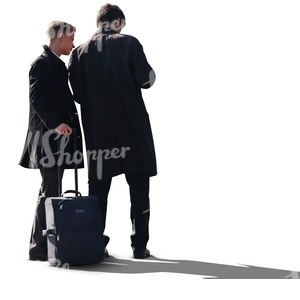 two men in coats standing and looking at smth