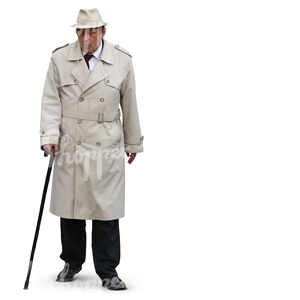 elderly man in a trenchcoat and hat walking