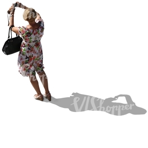backlit woman in a summer dress taking a picture