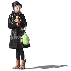 young girl in a winter coat standing and eating a snack