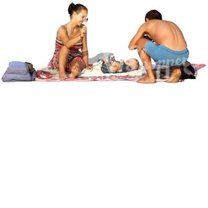 family with a small baby relaxing on the beach