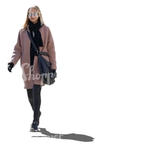 backlit woman in a pink coat walking