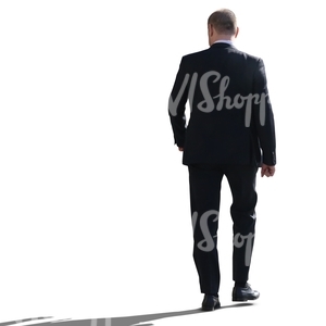 backlit businessman walking seen from behind