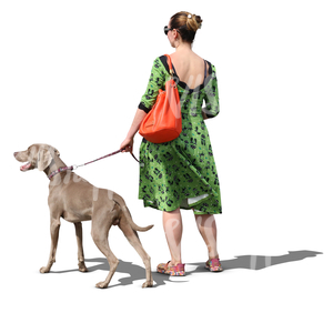 woman in a green dress walking a dog