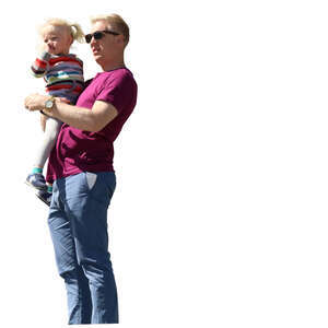 man standing and holding his daughter in his arms