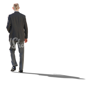 backlit businessman in a grey suit walking