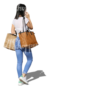 woman with shopping bags walking and talking on the phone